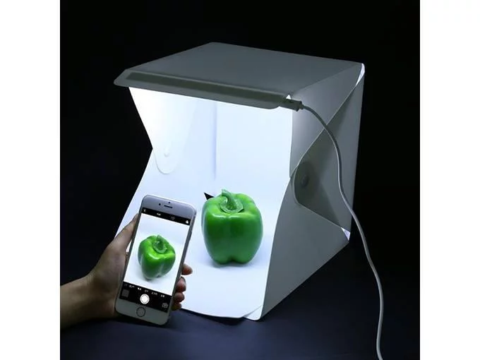 { "alt_text": "Portable photo studio box with LED lights and backgrounds" }
