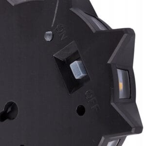 a black circular object with a white button