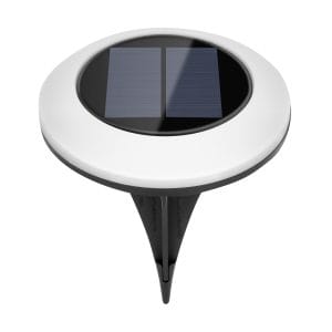Štiri okrogle talne solarne svetilke svetijo na travniku ponoči