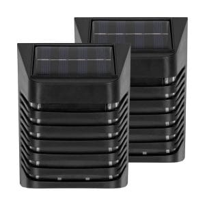 Dve črni moderni solarni stenski svetilki svetita navzdol na leseni fasadi